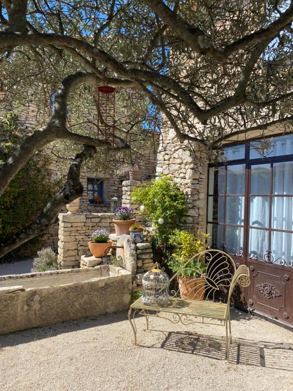 a bench in front of a building with a basketball hoop at Mas de la Beaume in Gordes