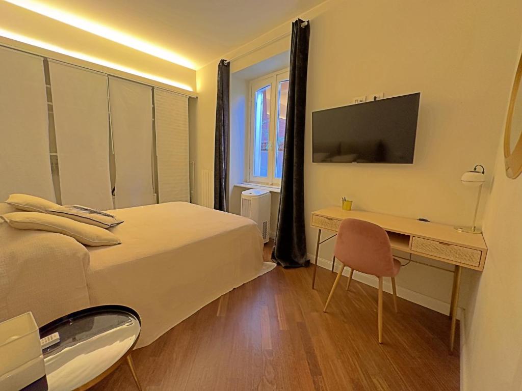 een slaapkamer met een bed, een bureau en een televisie bij Appartme Stampa 2 in Milaan
