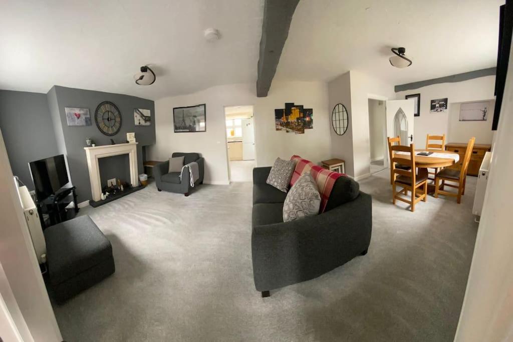 a living room with a couch and a dining room at Stunning Two bed cottage in Rhuddlan