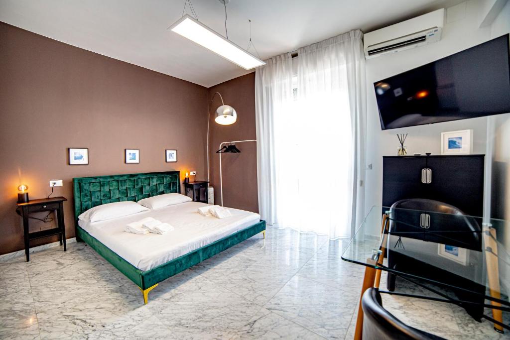 um quarto com uma cama grande e uma televisão em Splendida camera vista mare con terrazza e finiture di lusso em Marina di Carrara