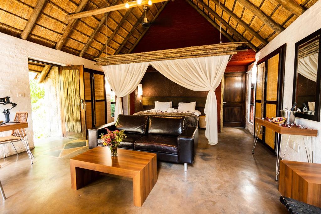 a bedroom with a bed and a couch and a table at Hakunamatata Lodge & Health Spa/ Wedding & Conference venue in Muldersdrift