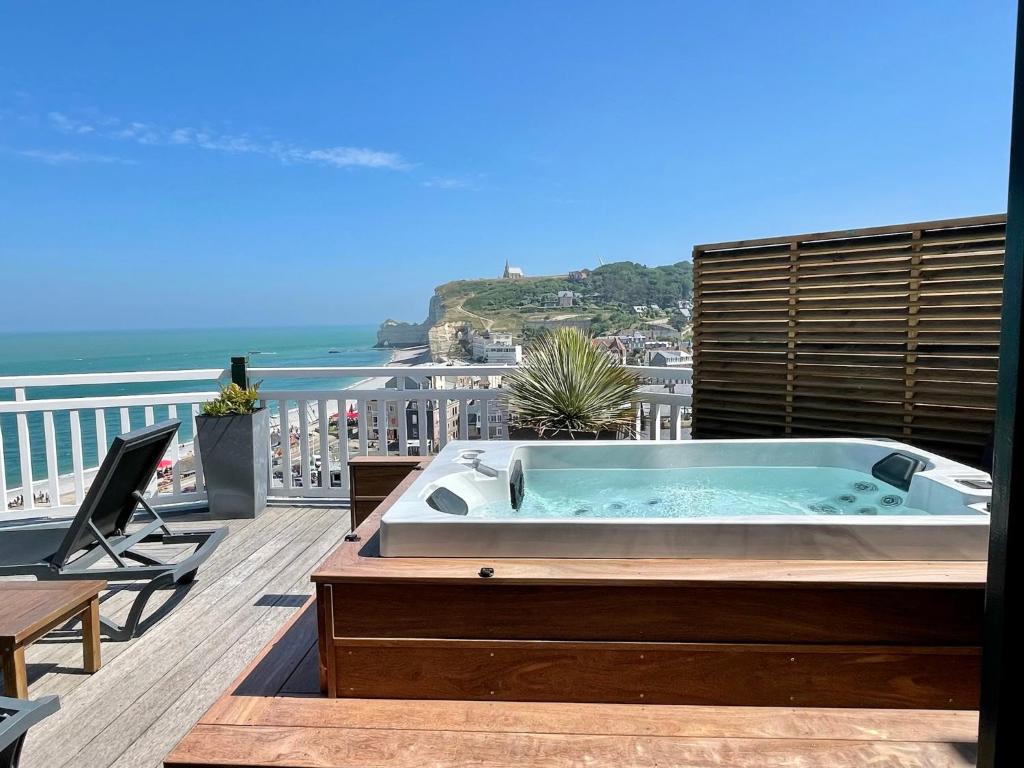 a hot tub on a balcony with a view of the ocean at Dormy House in Étretat