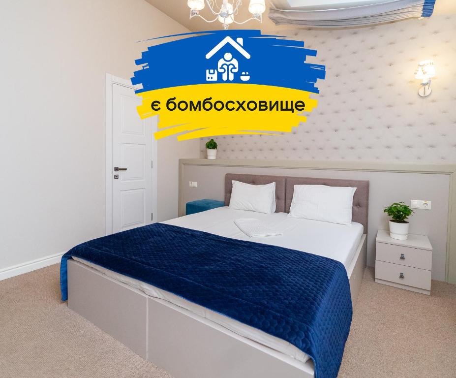 a bedroom with a bed with a blue and yellow sign at Maner hotel in Odesa