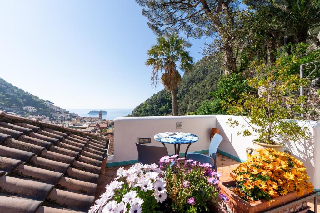 una mesa y sillas en un balcón con flores en Hotel Villa Annalara charme and relax, en Amalfi