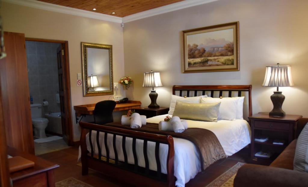 LUXURY ROOM @ 4 STAR GUEST HOUSE في ميدلبرغ: غرفة نوم مع سرير مع دبتين عليه