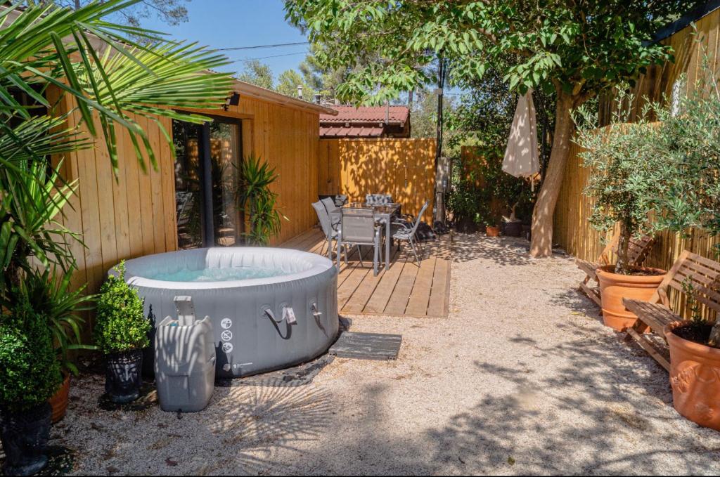 拉西約塔的住宿－Chalet nature proche plage，后院设有热水浴池、桌子和椅子