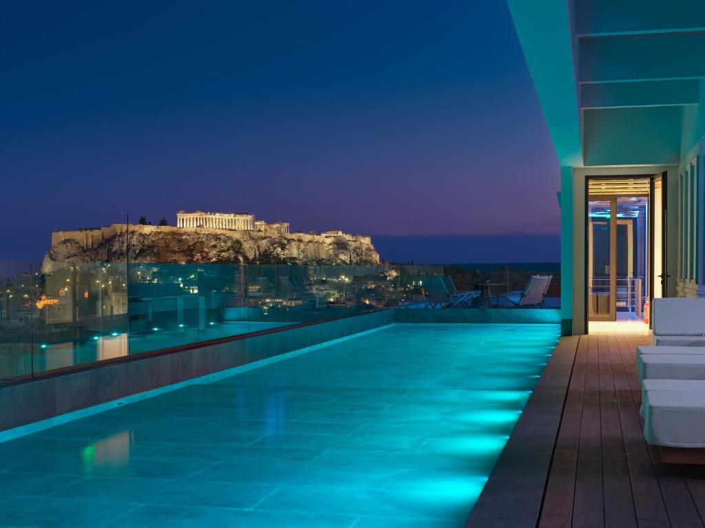 uma piscina do hotel com vista para a acrópole em NYX Esperia Palace Hotel Athens by Leonardo Hotels em Atenas