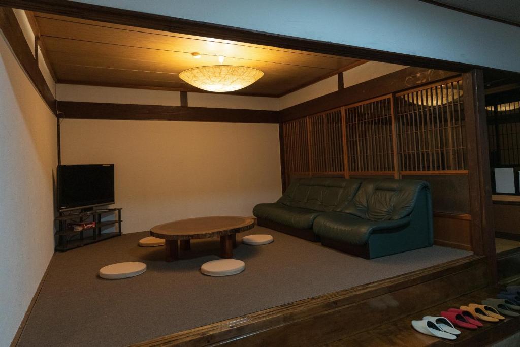 - un salon avec un canapé et une table dans l'établissement 交流宿　星降る家　いこい, à Gujō
