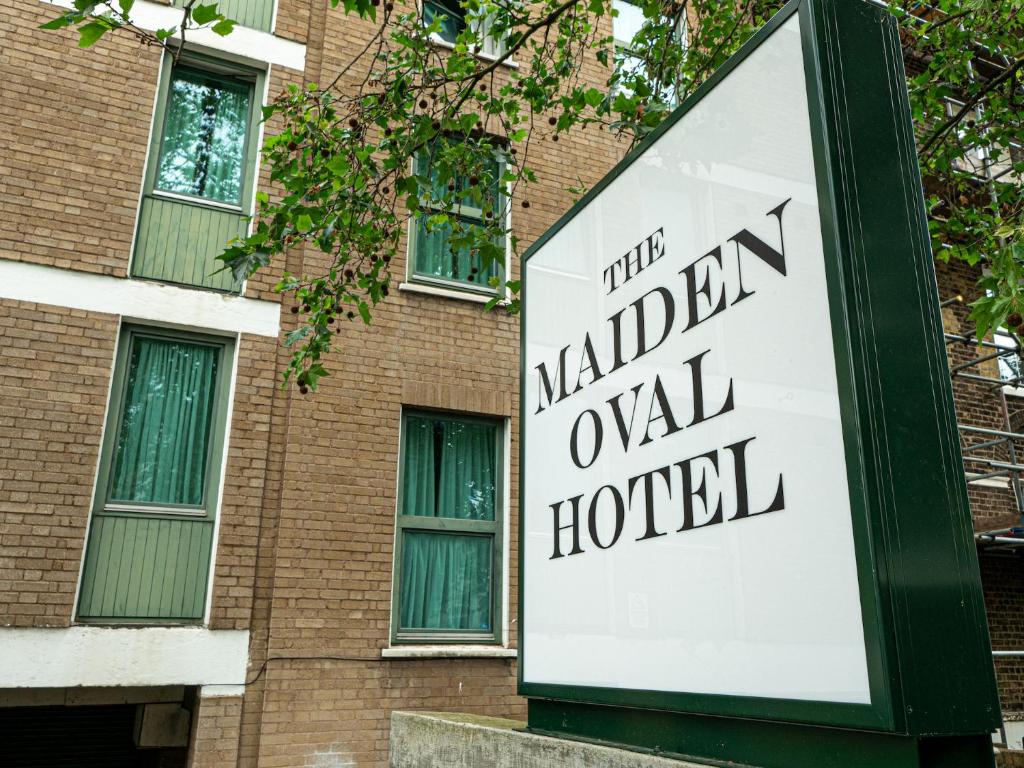 un cartello per un hotel di fronte a un edificio in mattoni di Maiden Oval a Londra