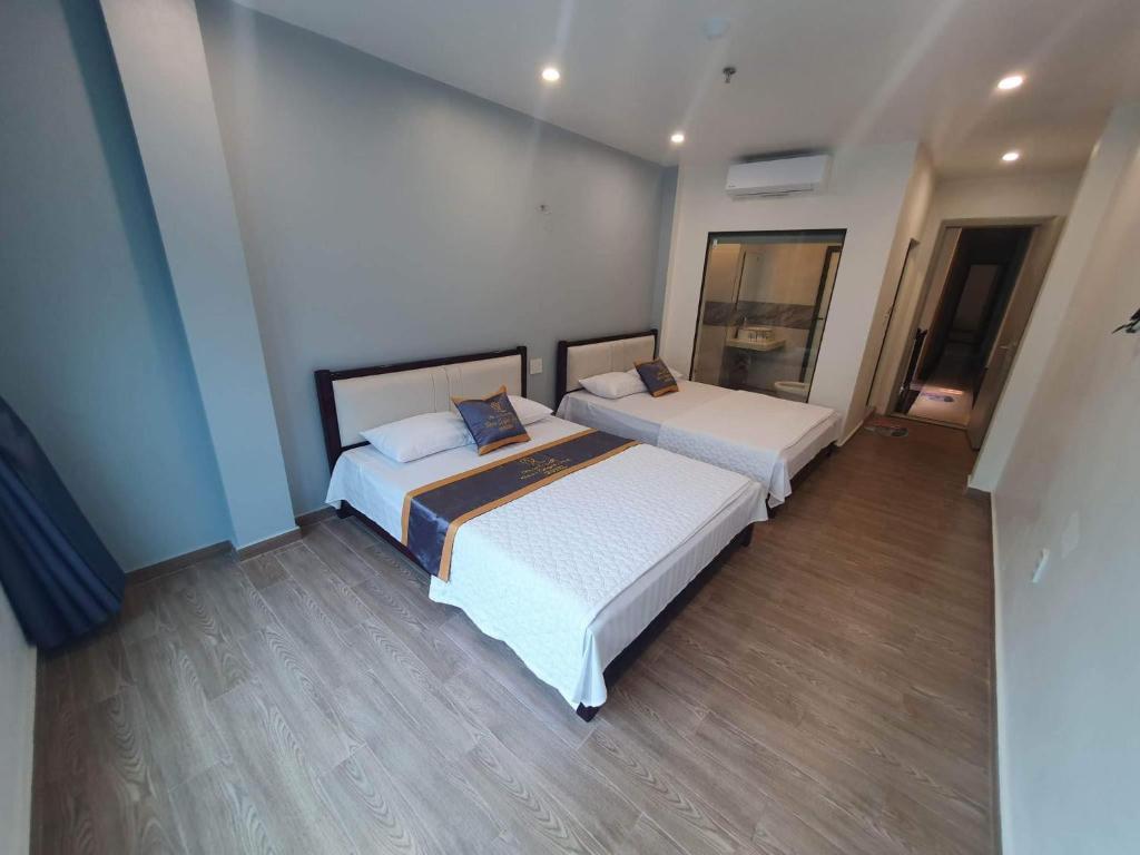 2 camas num quarto com pisos em madeira em Rosa Quỳnh Anh em Ilha de Cát Bà