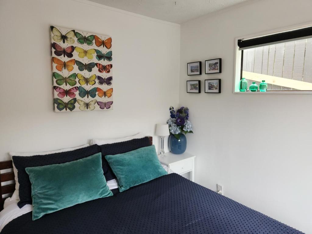 um quarto com uma cama com duas almofadas verdes em Studio 9 on Lakewood em Wellington