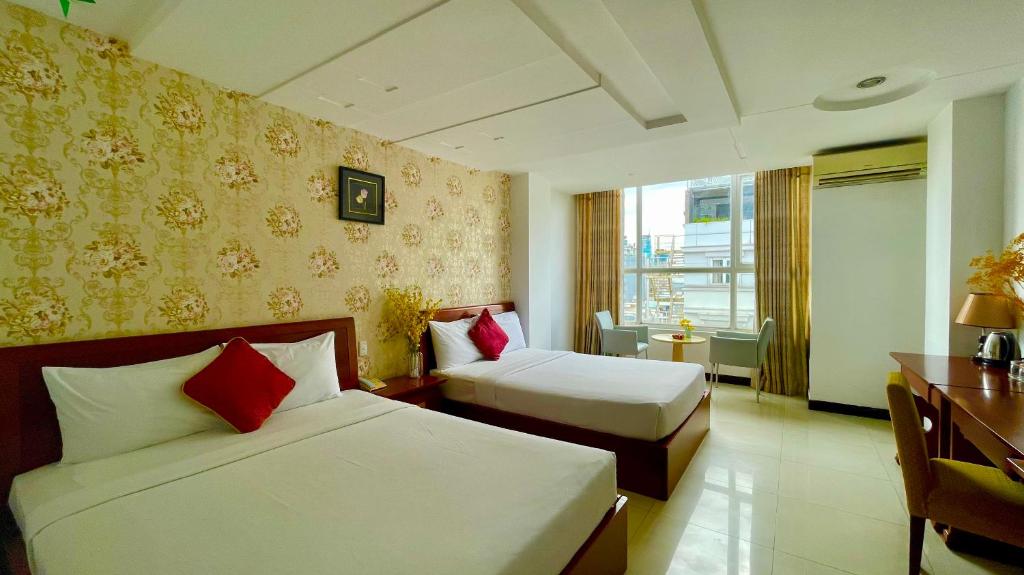 um quarto de hotel com duas camas e uma secretária em Gold hotel, Saigon em Cidade de Ho Chi Minh