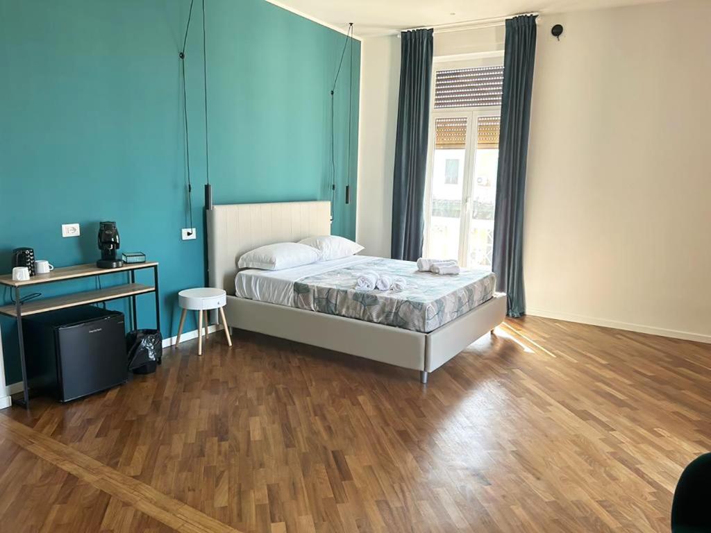 una camera con letto, scrivania e pavimento in legno di ATTICO33 a Napoli