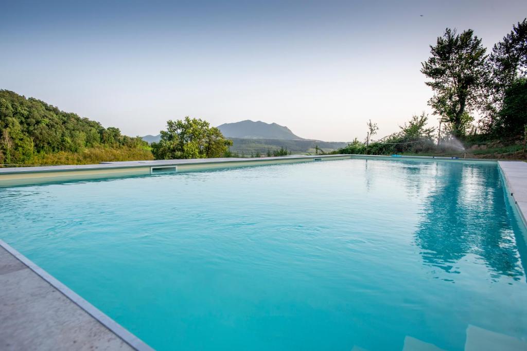 a large swimming pool with blue water at Luxury Country Villa Daniele in Poggio Sommavilla