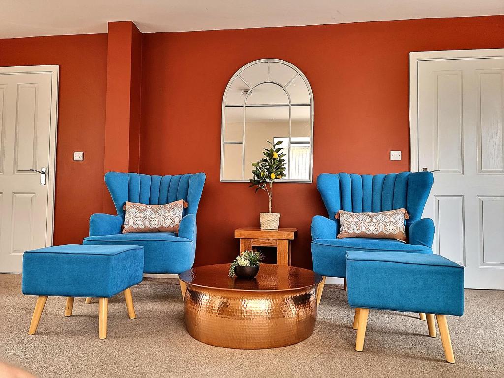 un soggiorno con 2 sedie blu e un tavolo di Detached House with Free Parking Long Stay Discounts a Thurcaston