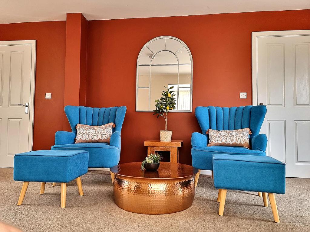 a living room with two blue chairs and a table at Detached House with Free Parking Long Stay Discounts in Thurcaston