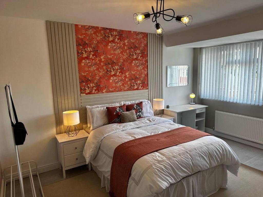 um quarto com uma cama com uma pintura vermelha na parede em Lovely 3-Bed House near Birmingham Airport & Nec em Solihull