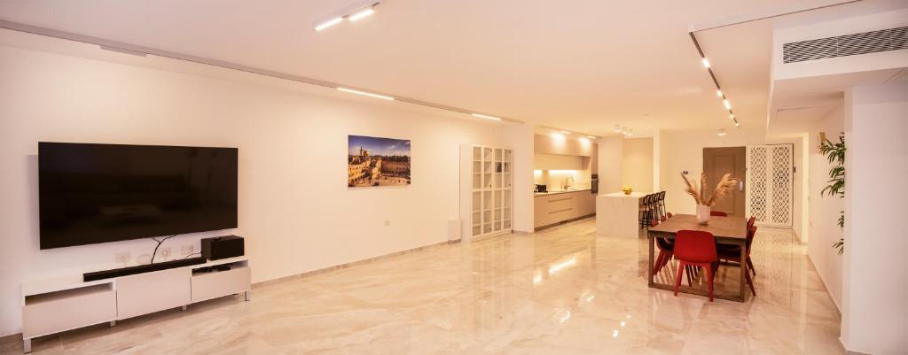 a living room with a large television and a table at Hapalmah one, Jerusalem, Dira 1 in Jerusalem