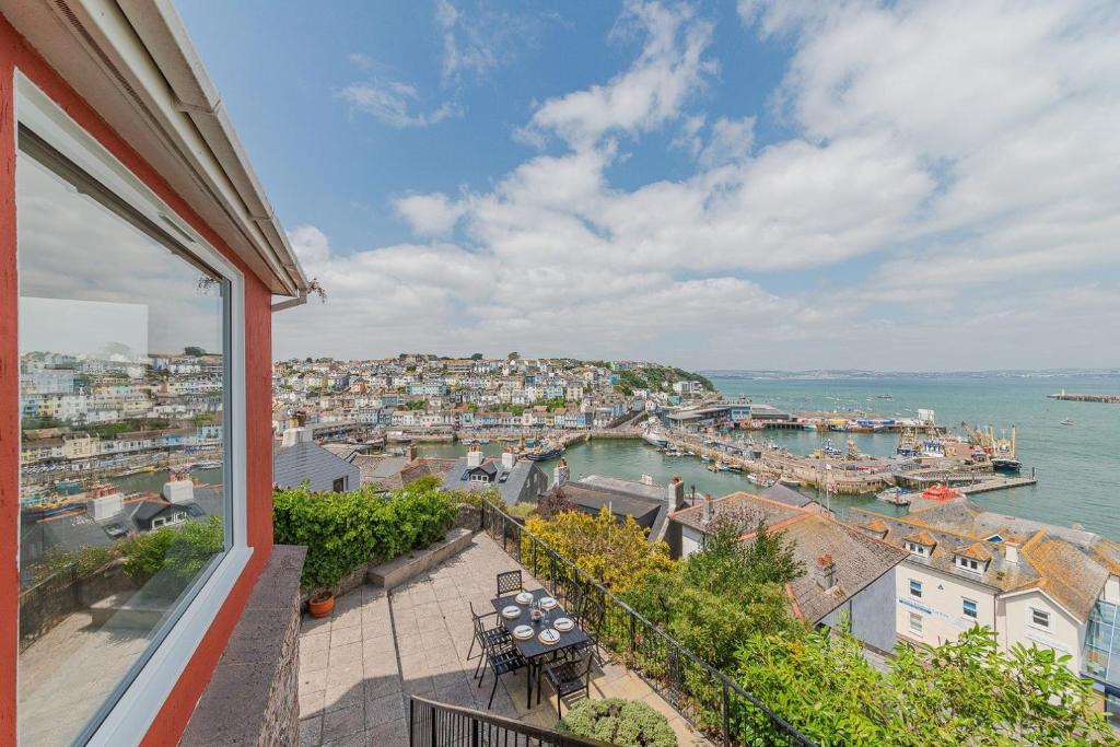 a balcony with tables and a view of a harbor at Driftwood - New Listing in Brixham