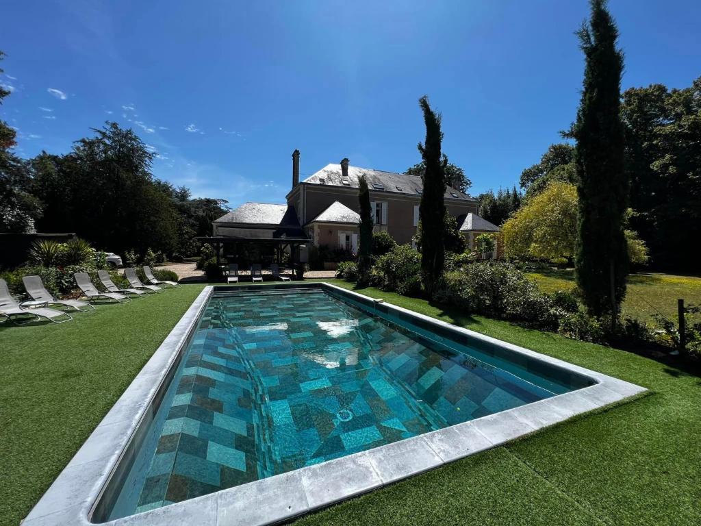a swimming pool in the yard of a house at Le grenier d'Odette in Sainte-Gemme-la-Plaine