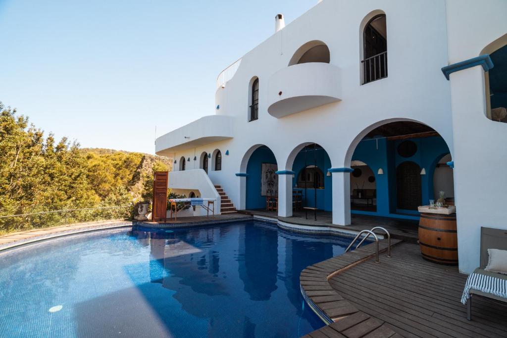 a swimming pool in front of a building at Oasis Living Can Nirvana - Best Sea Sunsets in Cala Tarida
