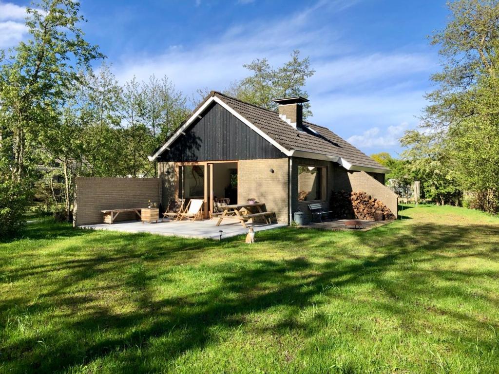 een klein huis in een veld met een grasveld bij Familiehuis Lytse Miede in Formerum