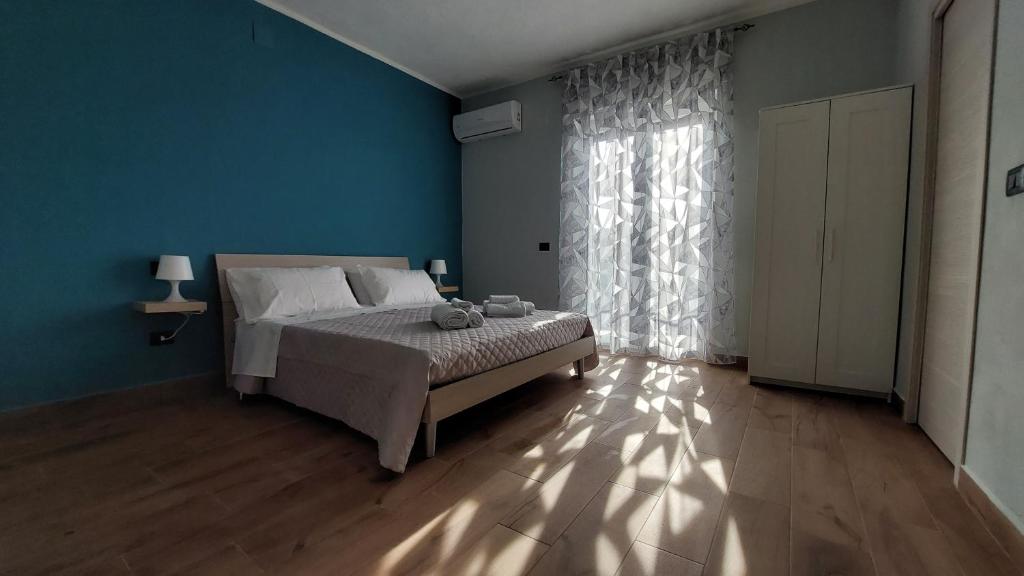 NoepoliにあるNirvana Bed and Breakfast Experienceの青い壁のベッドルーム1室(ベッド1台付)