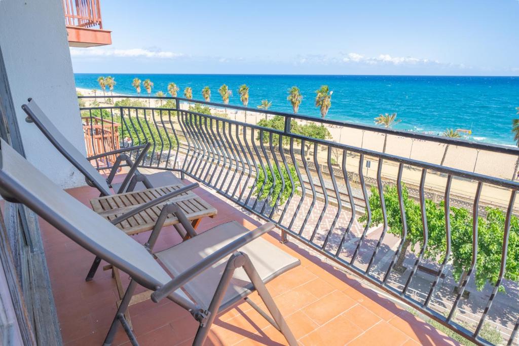 a balcony with two chairs and a view of the ocean at HomeHolidaysRentals Palm Beach - Costa Barcelona in Canet de Mar