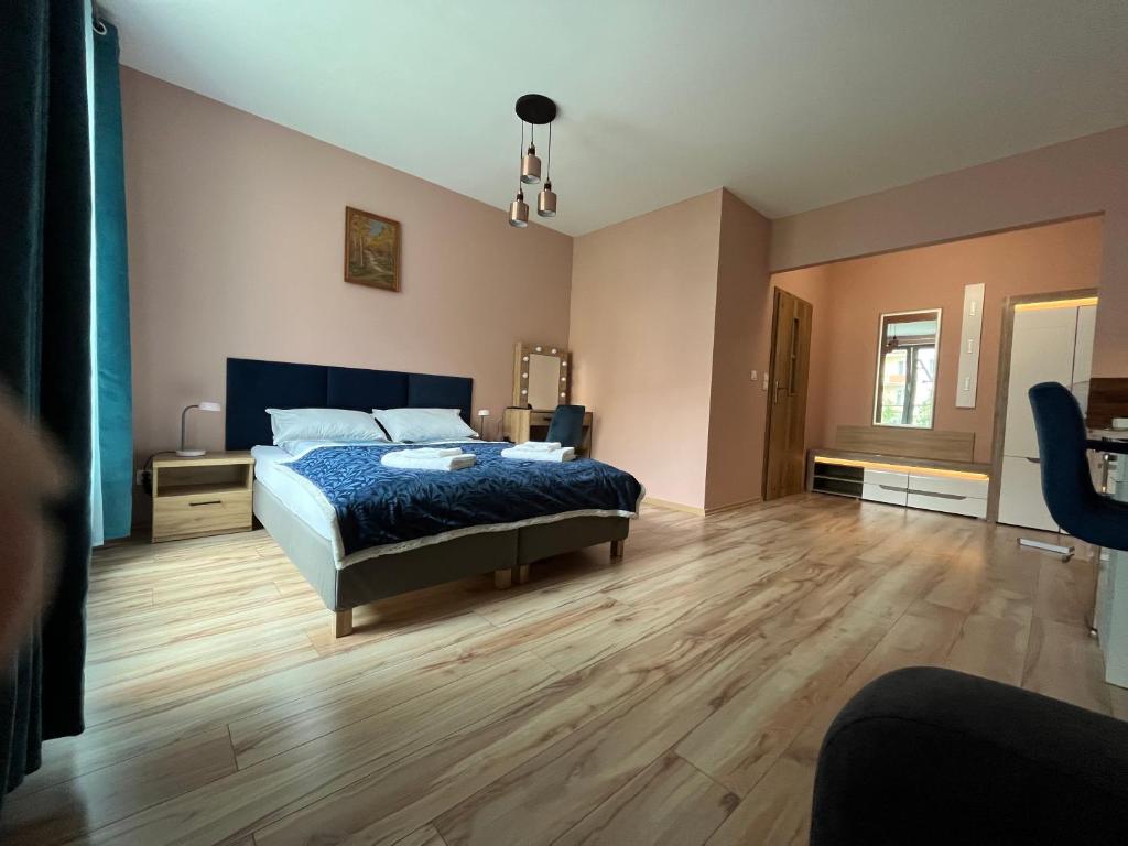 a bedroom with a bed and a wooden floor at Mona Sun Apart in Gdynia