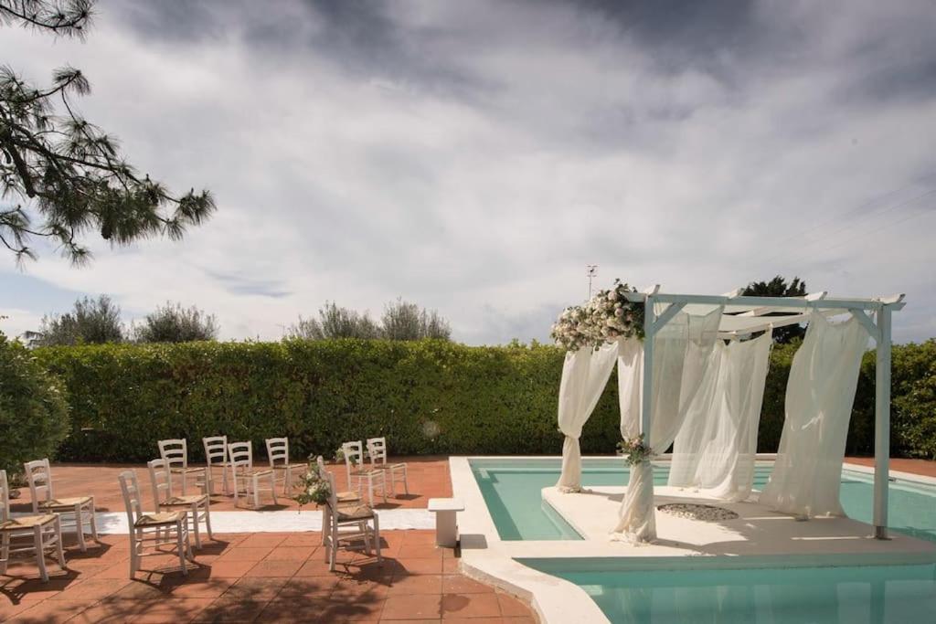 a wedding set up by a swimming pool with an arch and chairs at Villa con piscina mozzafiato, giardino e barbecue in Polignano a Mare