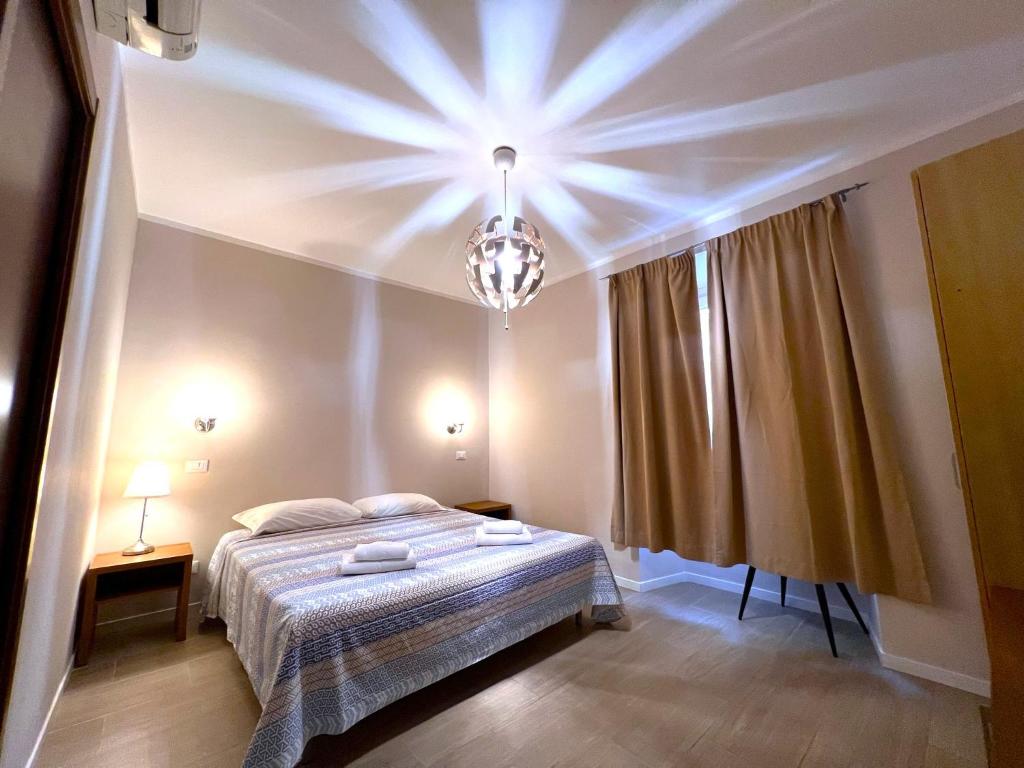 a bedroom with a bed and a chandelier at Hotel Sallustio in Rome