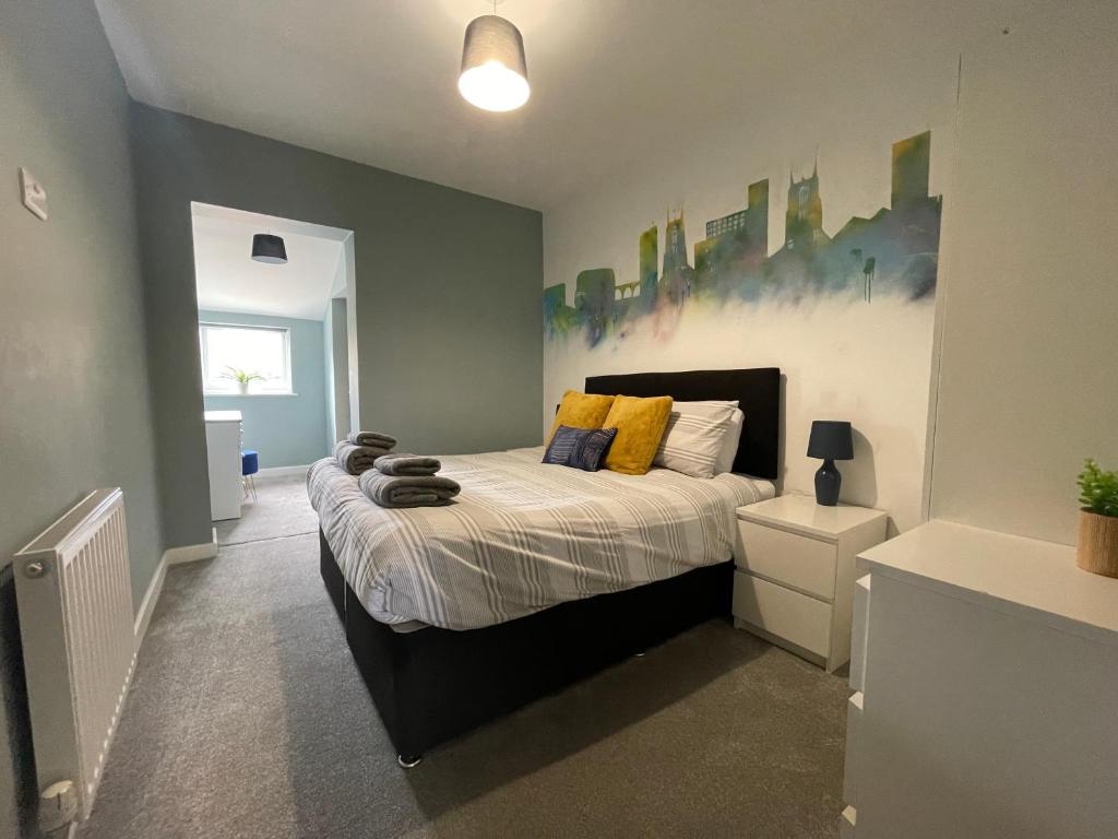 ein Schlafzimmer mit einem Bett mit gelben Kissen darauf in der Unterkunft Silk Apartments Spondon in Derby