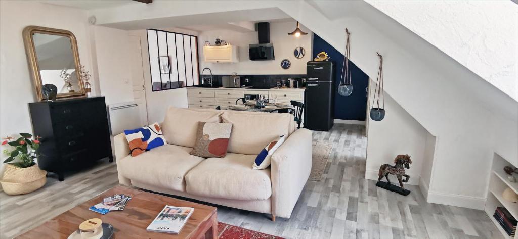 uma sala de estar com um sofá e uma cozinha em Bleu - Éden - appartement moderne en hypercentre em Vichy