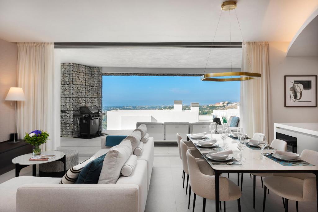 ein Wohnzimmer mit einem weißen Sofa und einem Tisch in der Unterkunft Real de La Quinta Quercus Serenity Luxury Seaview Apartment Marbella in Benahavís