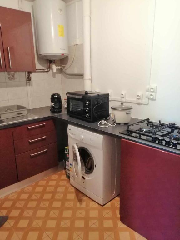 a kitchen with a washing machine and a microwave at Chez Denis et Lucie in Saint-André