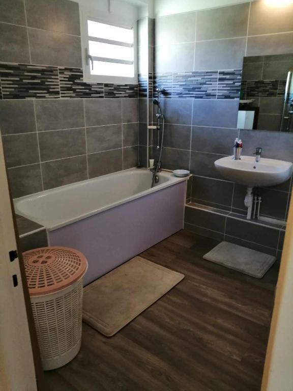 a bathroom with a bath tub and a sink at Chez Denis et Lucie in Saint-André