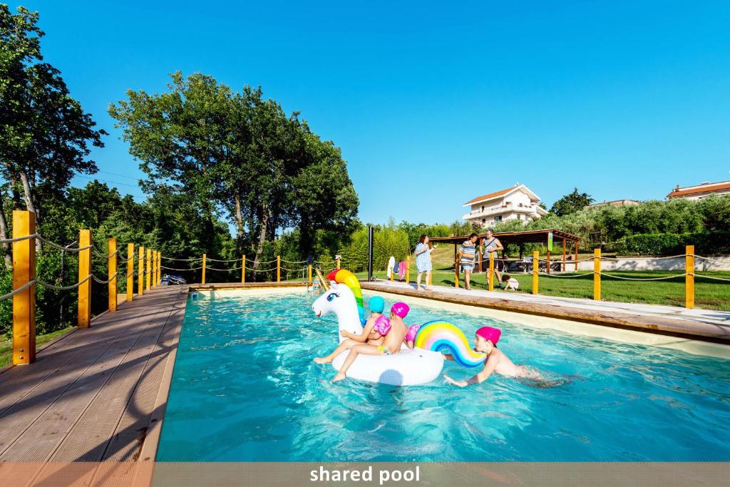 dos niños jugando en un unicornio inflable en una piscina en Livingapple, en Scauri