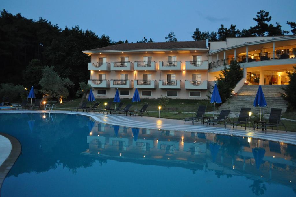a hotel with a swimming pool at night at Kohylia by La Scala Beach in Limenas