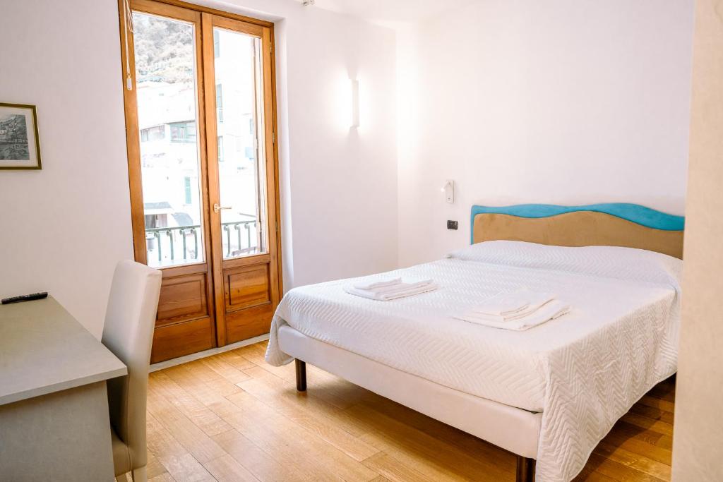 a white bedroom with a bed and a window at Residenza Ester in Amalfi