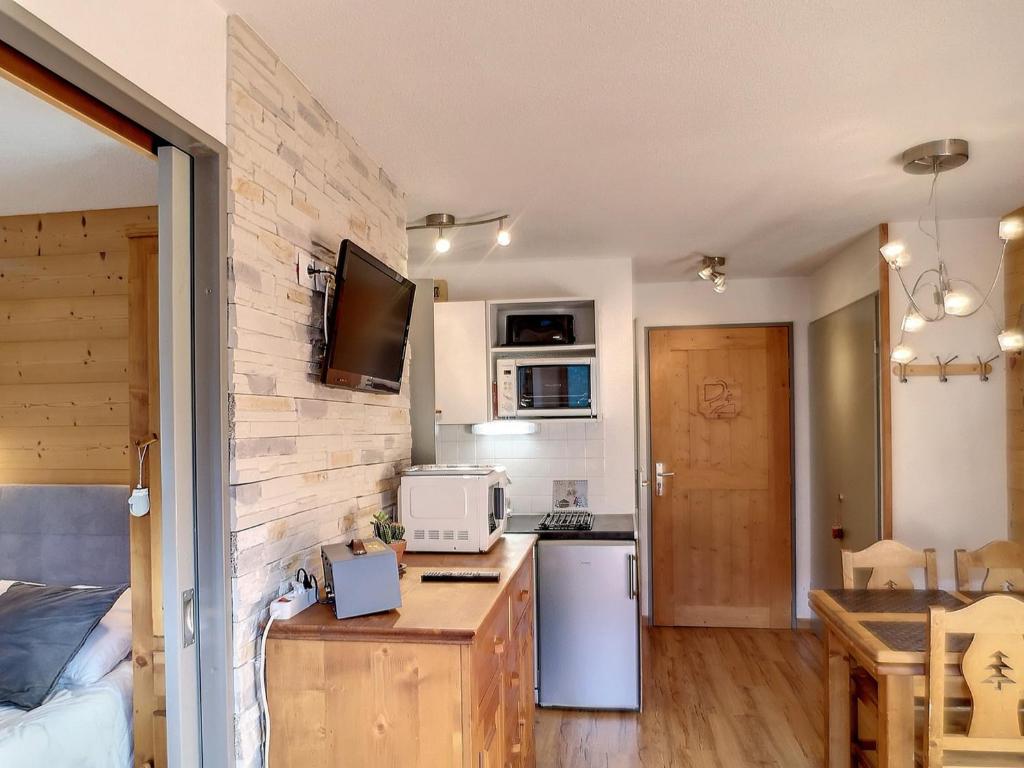eine kleine Küche mit einer Theke mit einer Mikrowelle und einem Herd in der Unterkunft Appartement Les Menuires, 2 pièces, 2 personnes - FR-1-178-171 in Les Bruyères