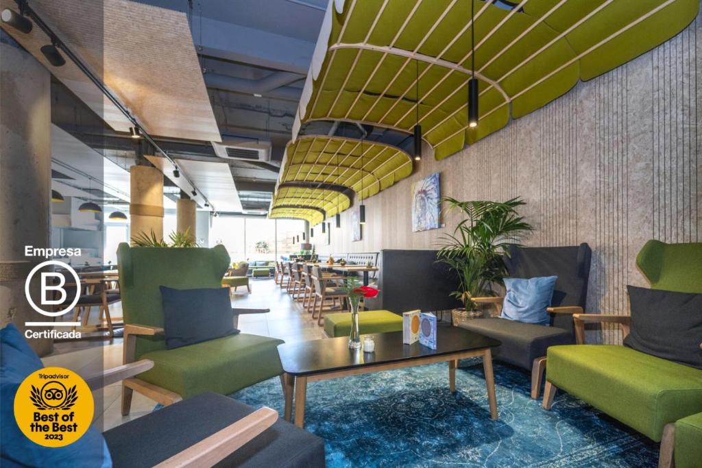 una hall con sedie verdi e tavoli in un ristorante di ARTIEM Madrid a Madrid
