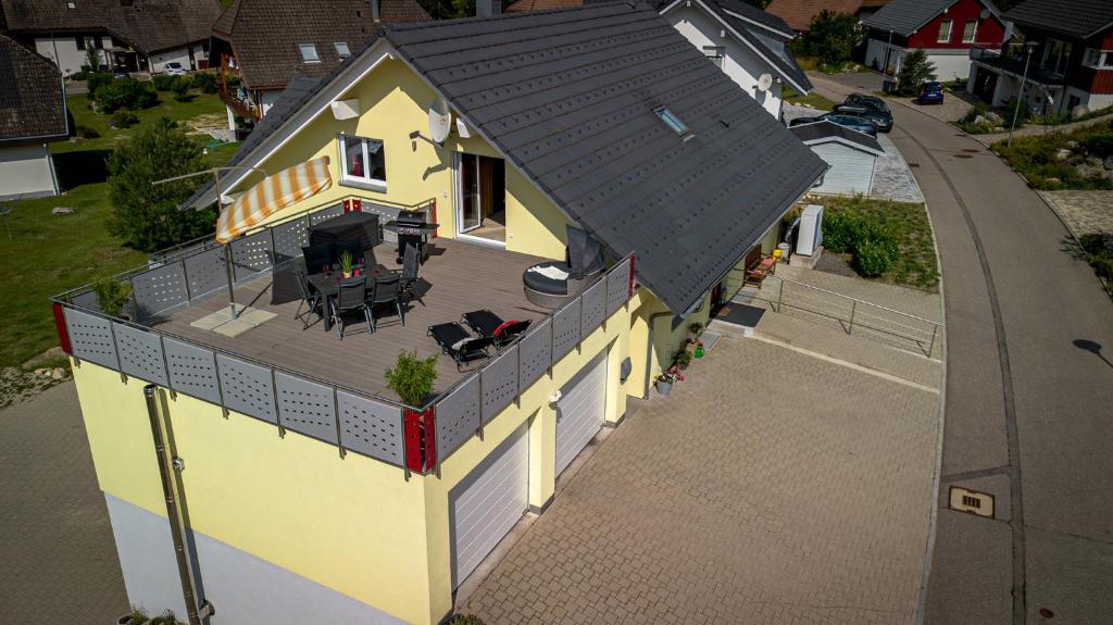 Elle offre une vue sur une maison jaune dotée d'une terrasse. dans l'établissement Ferienwohnung Mayer, à Schluchsee