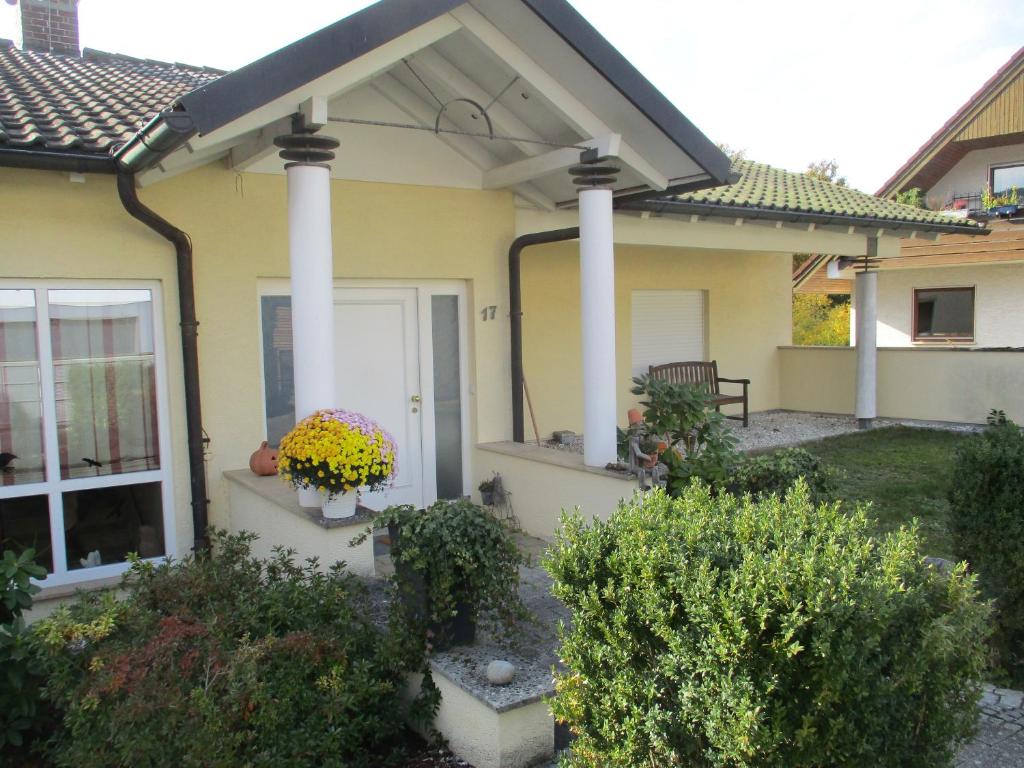 a yellow house with white columns and a porch at Ferienwohnung am Sulzbach in Sulzburg