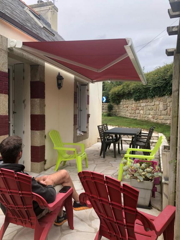 a man sitting in a chair on a patio at Penty de Kervillerm in Douarnenez