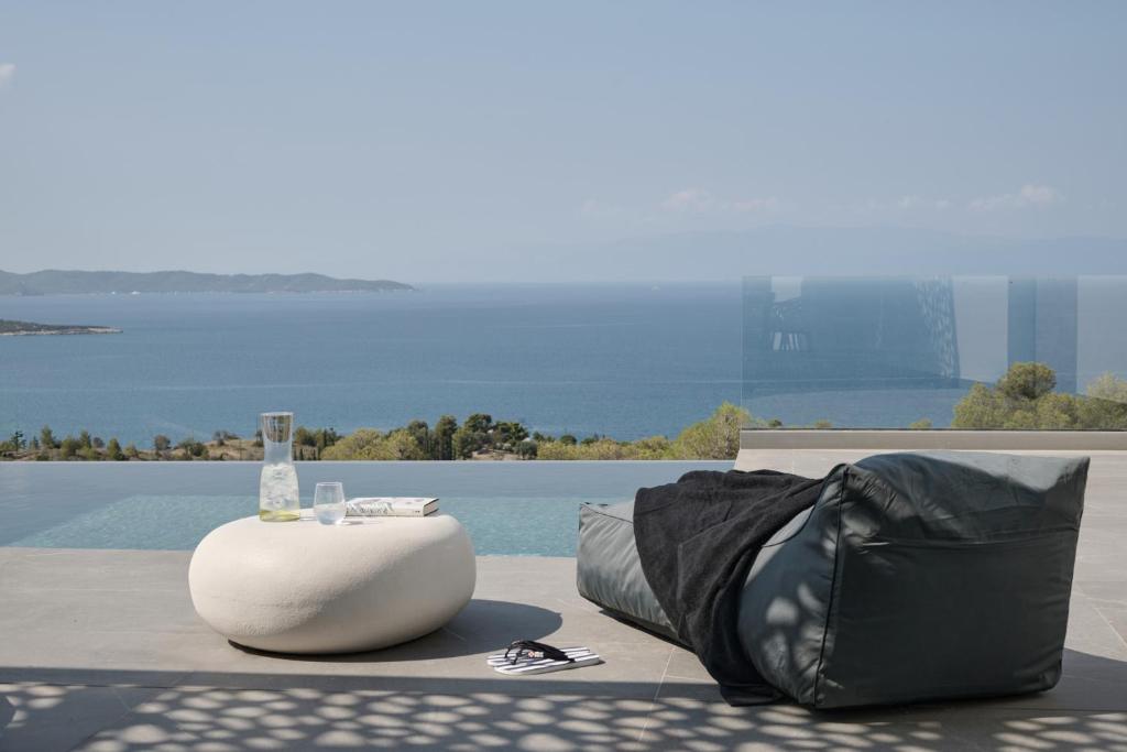 een tas en een tafel met een drankje op de grond bij Olvos Luxury Villas Porto Heli in Porto Cheli