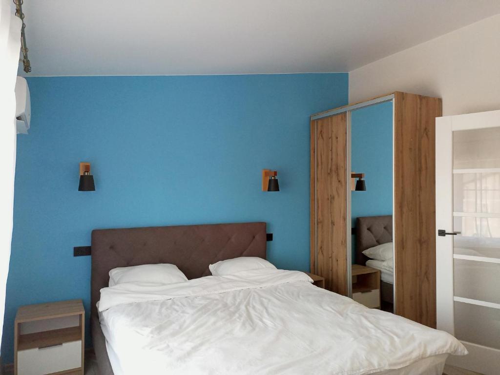 a bedroom with a bed with a blue wall at Apartment in Bozdosh estate in Uzhhorod