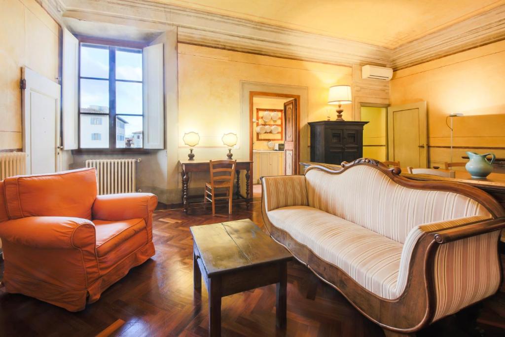 ein Wohnzimmer mit einem Sofa und einem Stuhl in der Unterkunft Apartments Florence- Borgo Pinti with Frescoes in Florenz