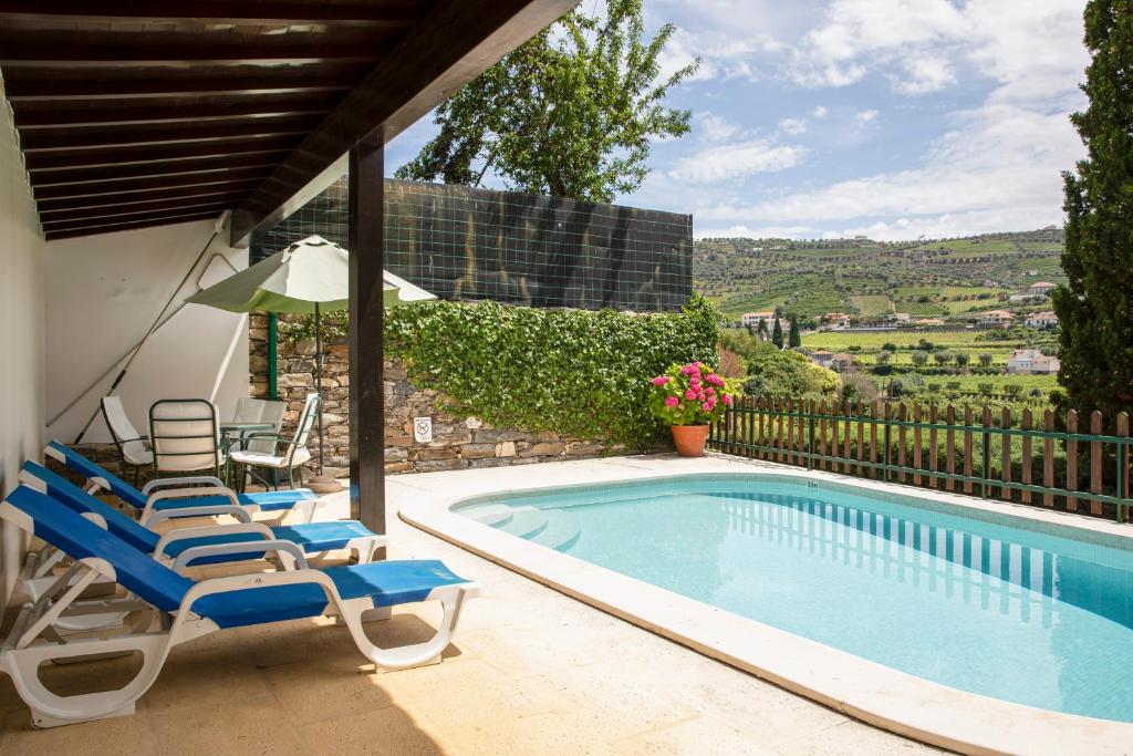 ein Swimmingpool mit Liegestühlen und Sonnenschirm in der Unterkunft Casa de São Bernardo by LovelyStay in Lamego