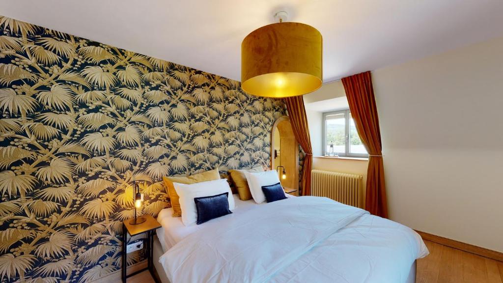 a bedroom with a bed with a blue and gold wallpaper at Les chambres de la Vaulx-Renard in La Gleize