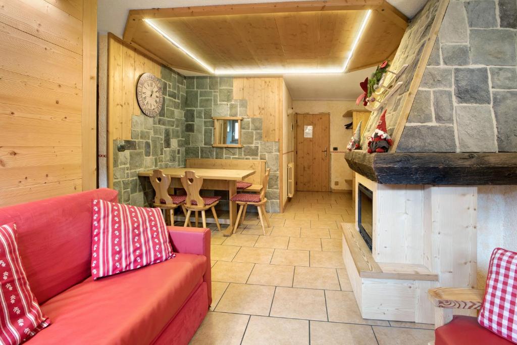 ein Wohnzimmer mit einem roten Sofa und einem Kamin in der Unterkunft Baita dei ski app 1 in Livigno